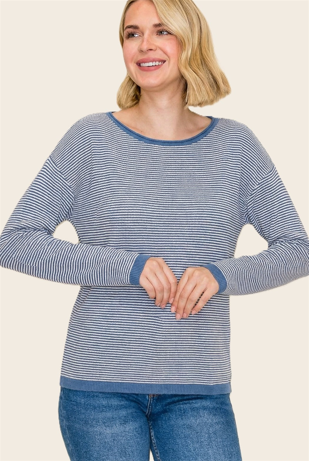 woman wearing a blue and white striped long sleeve sweater with a relaxed fit and contrasting neckline and cuffs