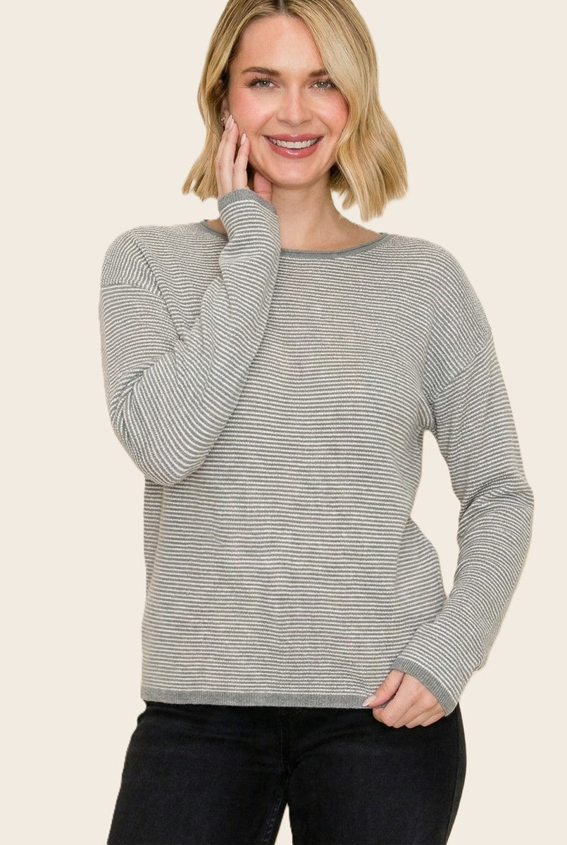 woman wearing a gray and white striped long sleeve sweater with a relaxed fit and round neckline