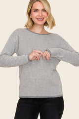 woman wearing a gray and white striped long sleeve sweater with wide neckline and relaxed fit