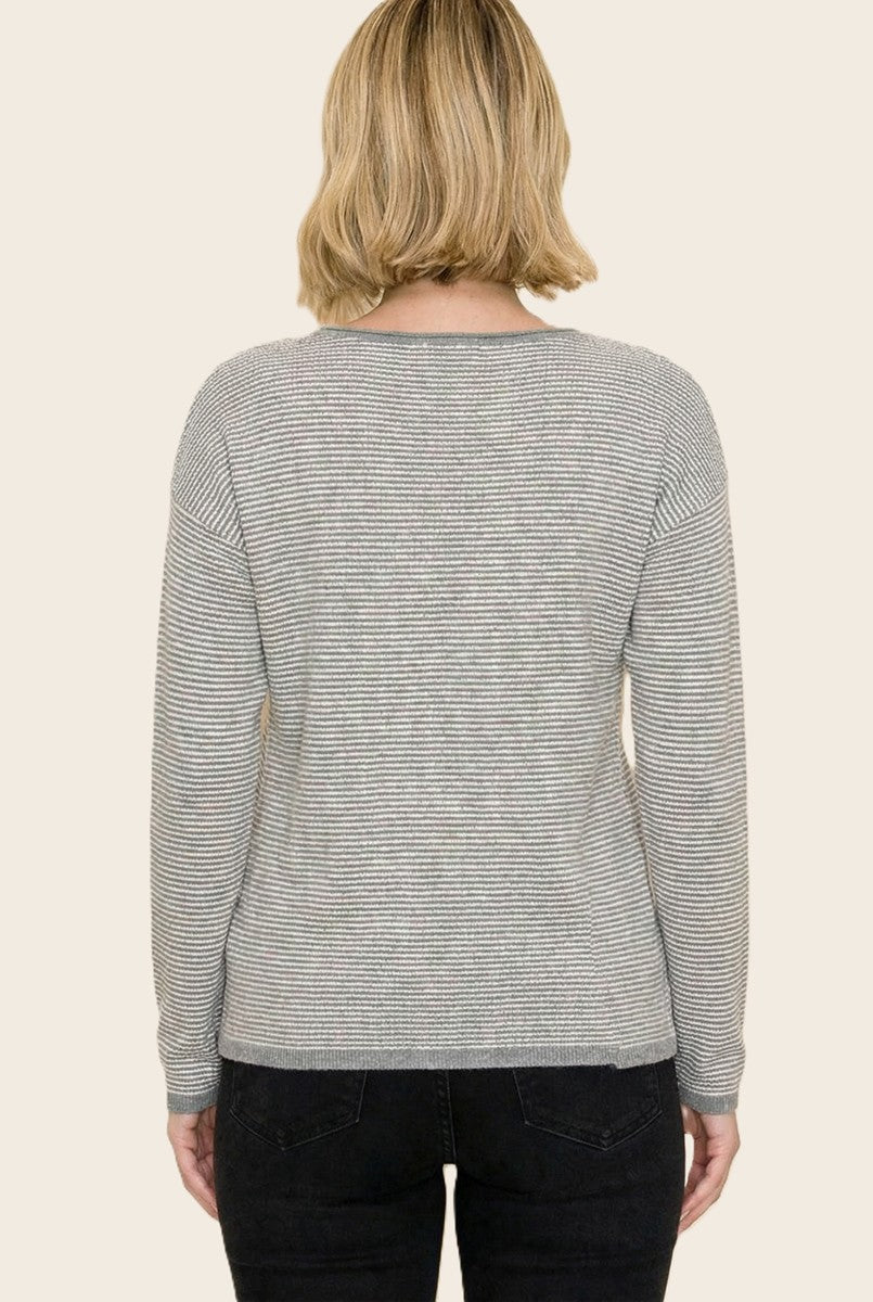 woman wearing a gray and white striped long sleeve sweater with a relaxed fit, viewed from the back