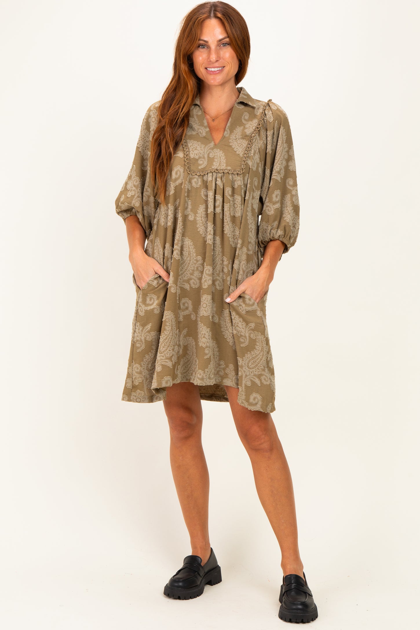 woman wearing a khaki paisley print short dress with puff sleeves and side pockets