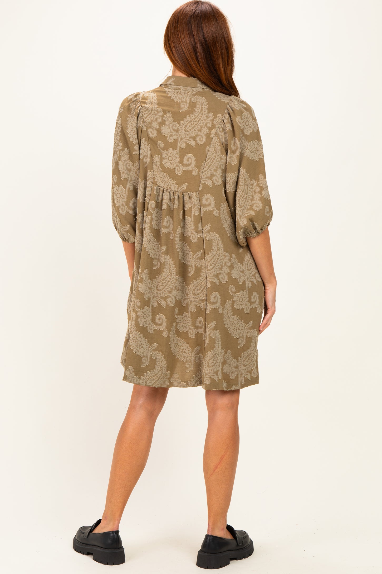 woman wearing a taupe paisley print short dress with puff sleeves and a relaxed fit, viewed from the back