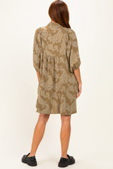 woman wearing a taupe paisley print short dress with puff sleeves and a relaxed fit, viewed from the back