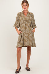woman wearing a brown paisley maternity dress with a collar, short sleeves, and pockets