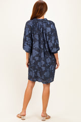 woman wearing a navy blue floral short dress with three-quarter puff sleeves, shown from the back