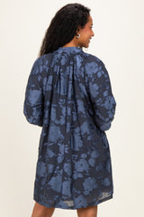 woman wearing a navy blue floral maternity dress with a flowy silhouette and gathered back details