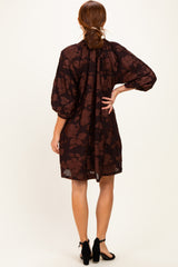 woman wearing a brown floral print puff sleeve dress, showing the back with a cinched waist and gathered neckline