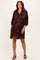 woman wearing a brown floral maternity dress with three-quarter sleeves and a relaxed fit, showing a baby bump