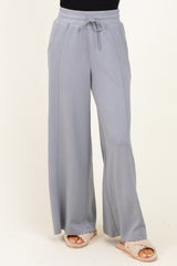 woman wearing light grey wide-leg lounge pants with drawstring waist and side pockets