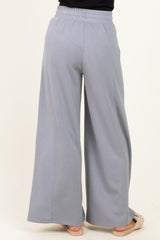 woman wearing light gray wide-leg sweatpants, seen from the back, with an elastic waistband and relaxed fit
