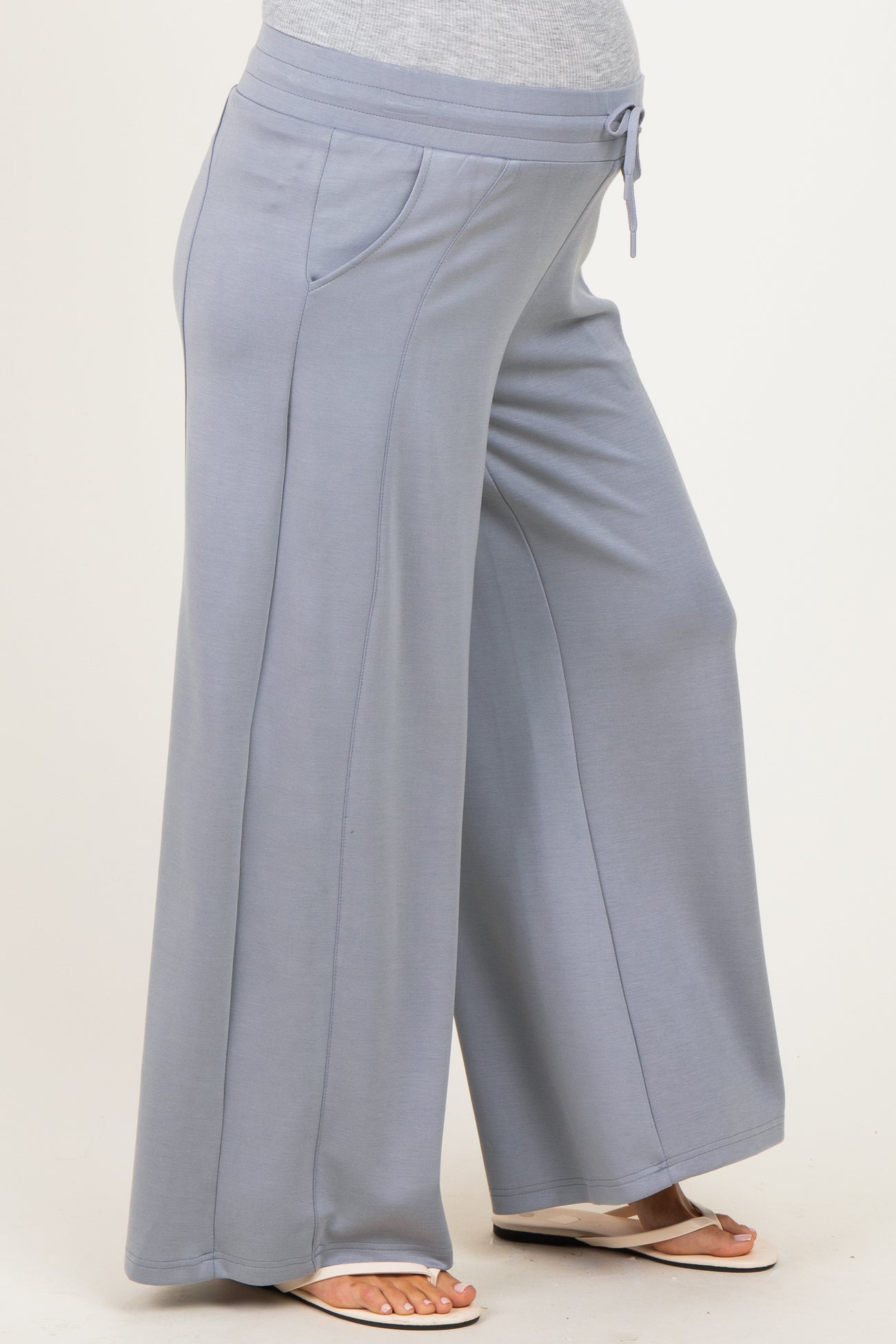 maternity wear light blue wide leg pants with a drawstring waist and side pockets, showcasing a visible baby bump