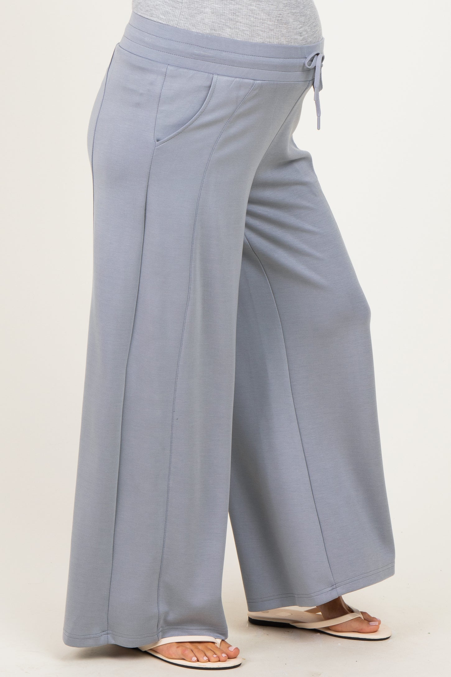 maternity wear light blue wide leg pants with a drawstring waist and side pockets, showcasing a visible baby bump