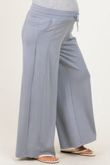 maternity wear light blue wide leg pants with a drawstring waist and side pockets, showcasing a visible baby bump