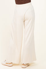 woman wearing white wide-leg pants viewed from the back, paired with sneakers