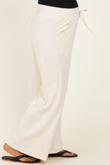 woman wearing cream maternity lounge pants with a drawstring waist and side pockets