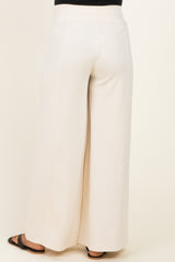 woman wearing cream wide-leg maternity pants, view from the back