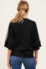 woman wearing a black maternity top with sheer sleeves and a relaxed fit, viewed from the back