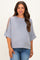 woman wearing a light grey maternity sweatshirt with sheer panels on the sleeves and a relaxed fit, smiling at the camera