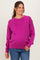 woman wearing a bright pink maternity sweater with long sleeves and a round neckline, smiling and showcasing her baby bump
