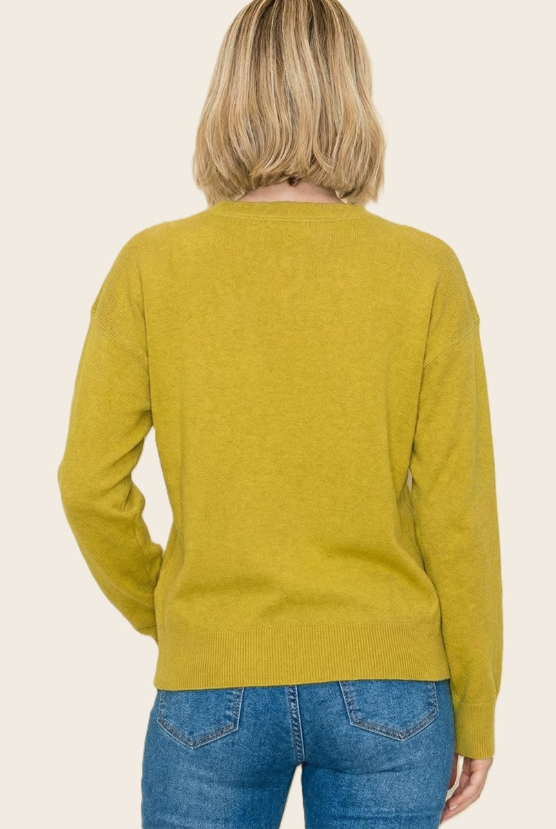 woman wearing a mustard yellow sweater with a relaxed fit and long sleeves, viewed from the back