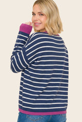 woman wearing a navy blue and white striped long sleeve sweater with purple accents, smiling and facing away from the camera