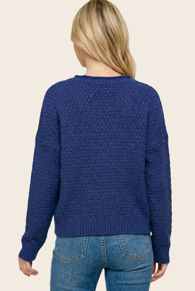 woman wearing a navy blue textured sweater with a relaxed fit, view from the back