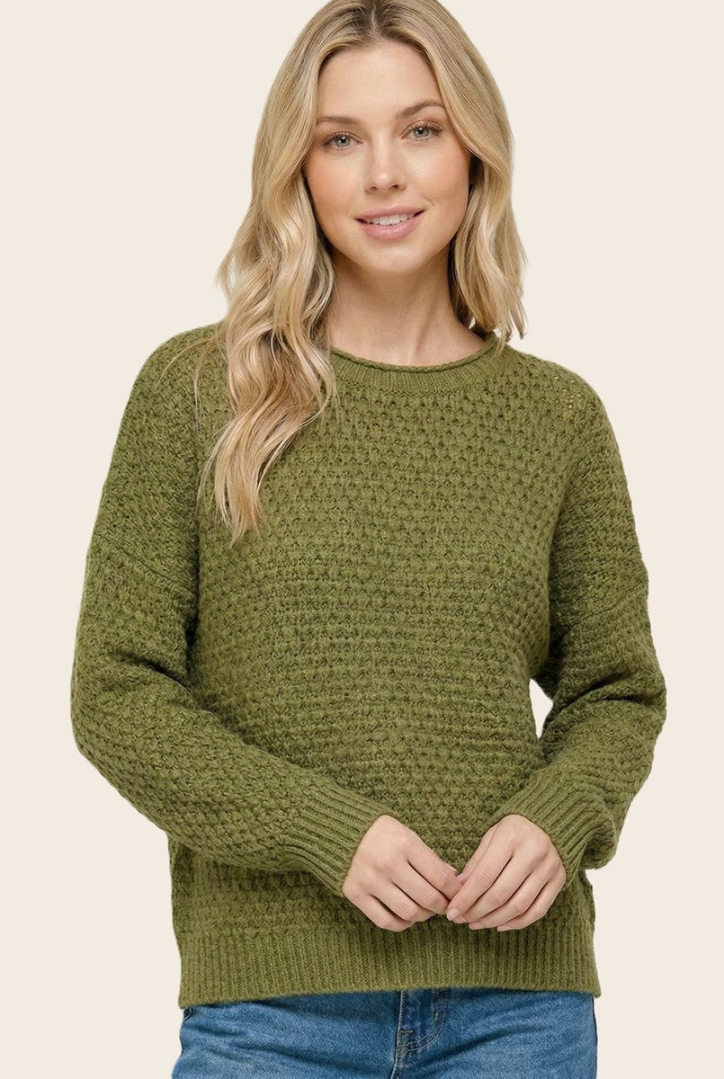 woman wearing an olive green textured knit sweater with a round neckline and relaxed fit