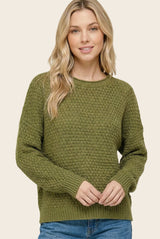 woman wearing an olive green textured knit sweater with a round neckline and relaxed fit