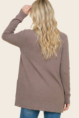 woman wearing a taupe long sleeve cardigan with a relaxed fit and pocket detail, shown from the back