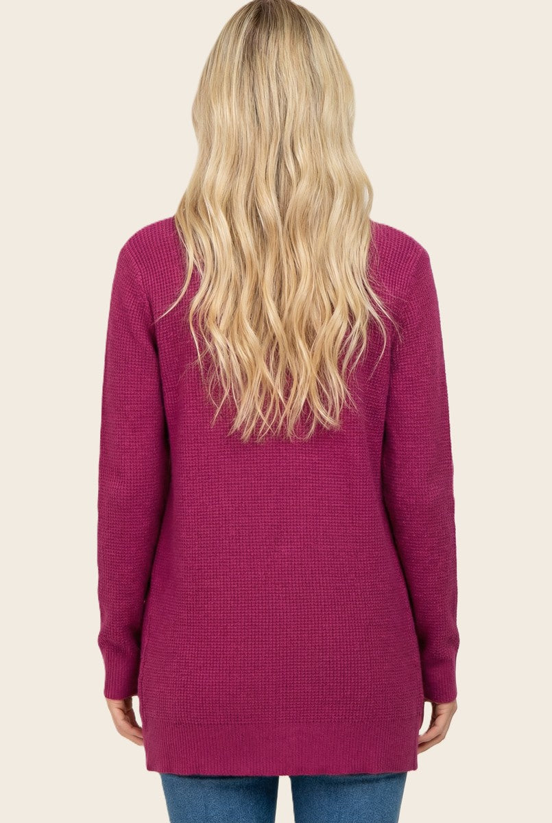 woman wearing a long-sleeve magenta sweater, view from the back, with loose fit and textured fabric