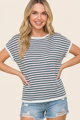 woman wearing a white and navy striped short sleeve top with rolled sleeves and distressed denim shorts