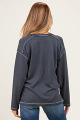woman wearing a navy blue long sleeve maternity top with a textured finish, seen from the back