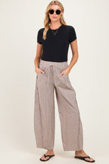 woman wearing a black short sleeve maternity top and relaxed striped maternity pants with pockets