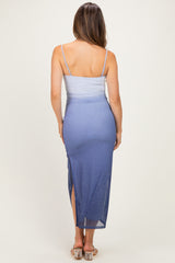 woman wearing a light blue maternity dress with a fitted top and a long, flowing skirt with a side slit