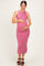 woman wearing a pink ribbed maternity dress, showcasing her baby bump with side ruching and a thigh-high slit