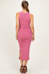 woman wearing a pink ribbed maternity dress with a side slit, showing her baby bump from the back
