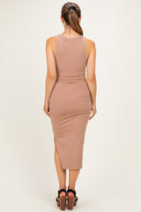 woman wearing a form-fitting mauve ribbed maternity dress with a midi length and side slit, showing her back