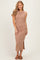 woman wearing a beige ribbed maxi dress with side ruching and a thigh-high slit, posing and smiling