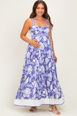 woman wearing a purple floral maternity maxi dress and holding her baby bump