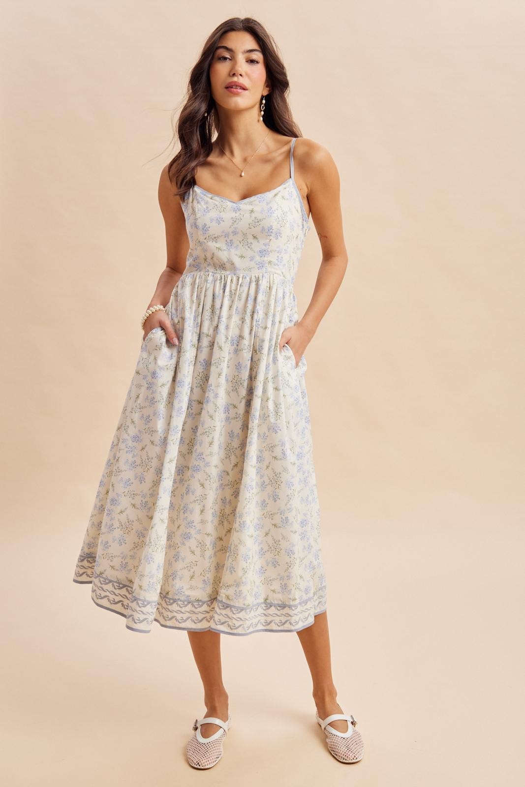 woman wearing a floral print maxi dress with thin straps and pockets, styled with espadrille flats