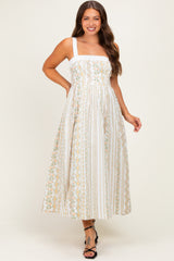 woman wearing a floral print maternity maxi dress with a square neckline and adjustable straps