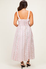 woman wearing a pink floral maternity maxi dress with a smocked back and adjustable straps