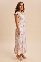 woman wearing a floral print maxi dress with ruffled sleeves and a flowy silhouette