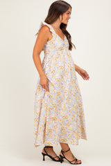 woman wearing a floral maternity maxi dress with ruffle straps and a visible baby bump