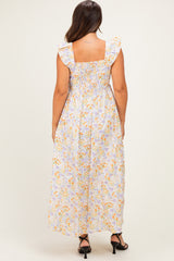 woman wearing a floral print maternity maxi dress with ruffle sleeves and a smocked back