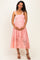 woman wearing a pink lace maternity dress with spaghetti straps and a visible baby bump