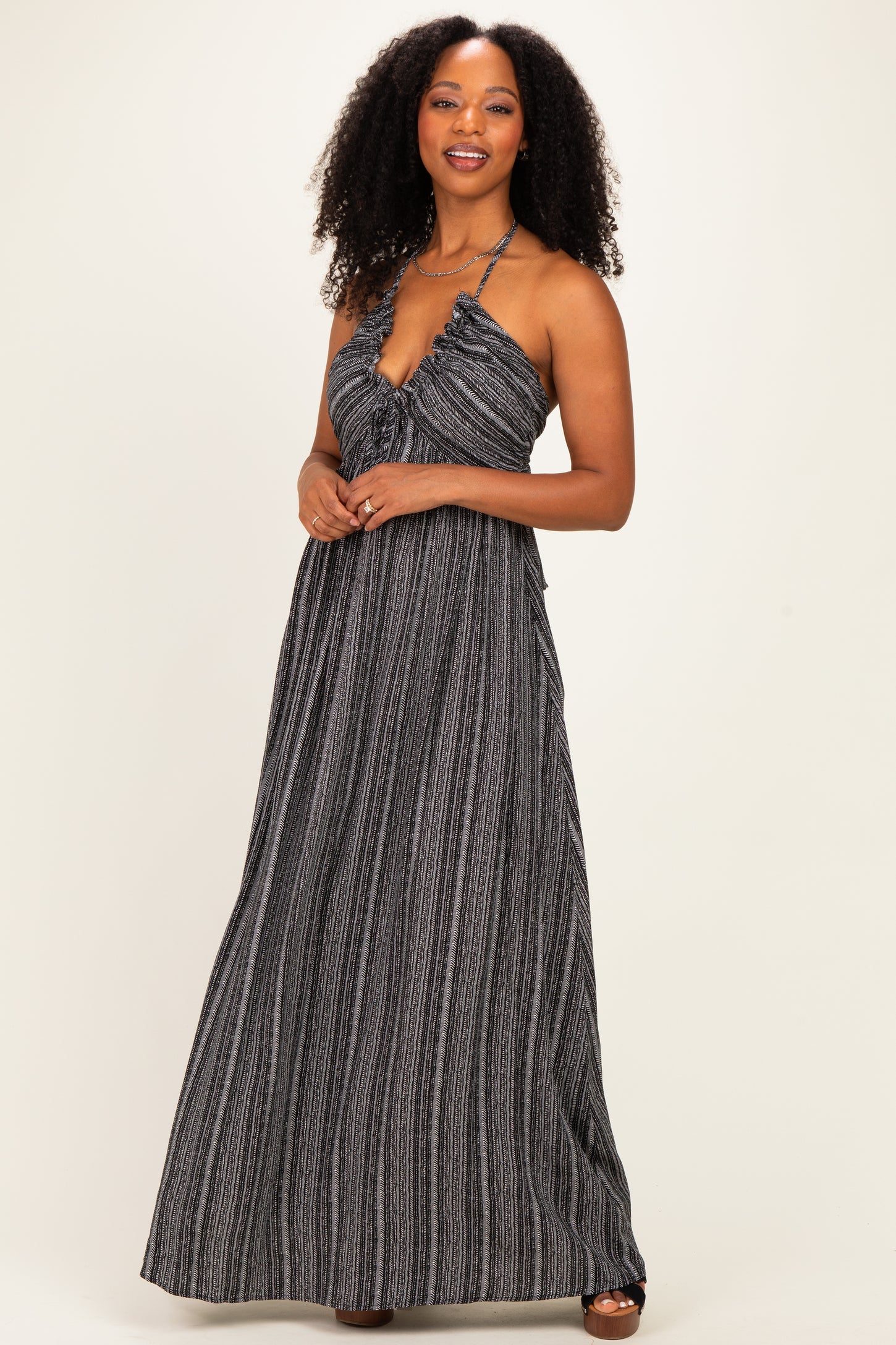 woman wearing a black and white striped maxi dress with a halter neckline and flowy silhouette