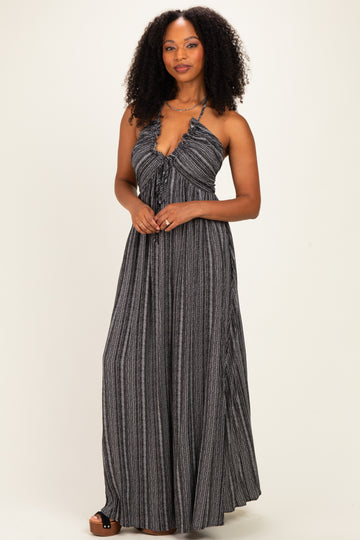 woman wearing a black and white striped halter neck maxi dress with a fitted bodice and flowy skirt