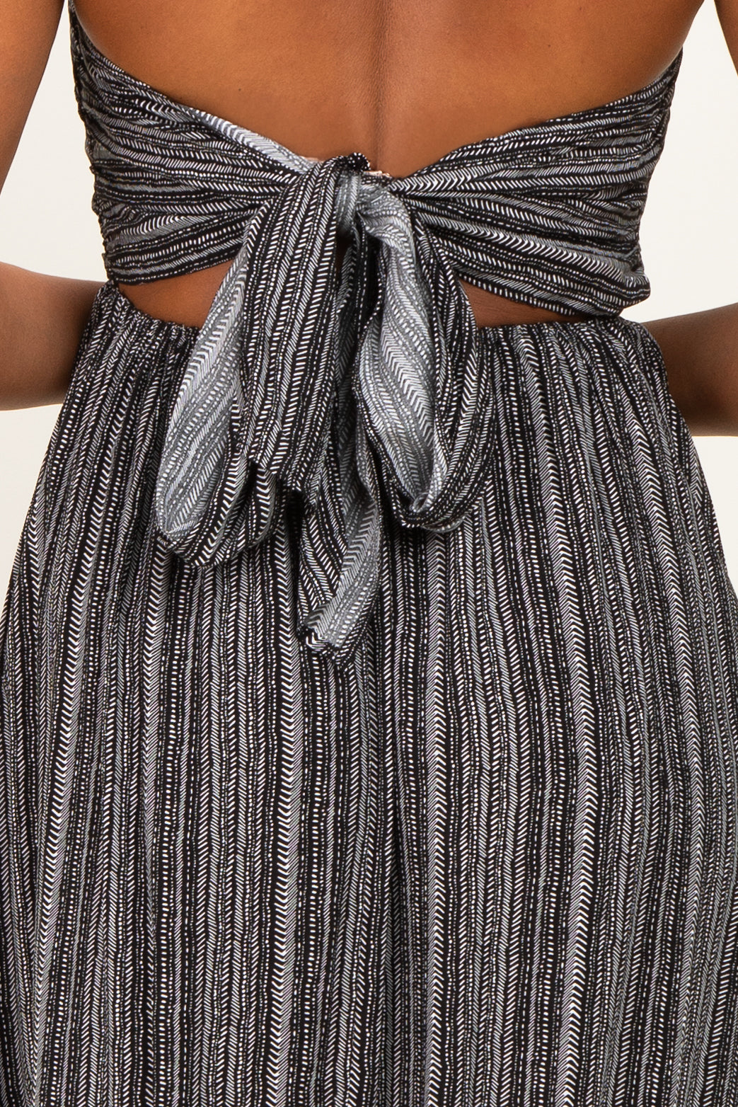 woman wearing a black and silver striped strapless dress with a tied back detail
