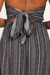 woman wearing a black and silver striped strapless dress with a tied back detail